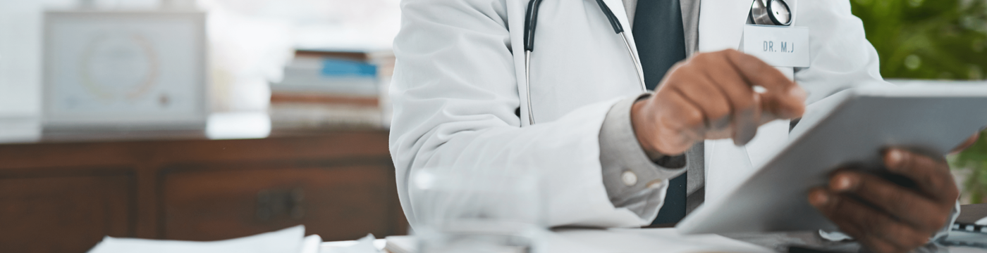 A doctor types on an electronic tablet