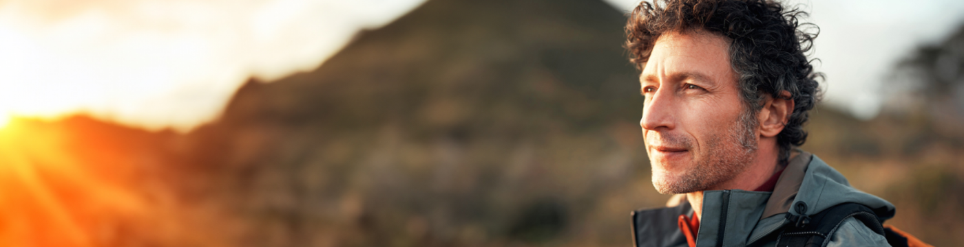 Headshot of an adventurous man with a mountain in the background