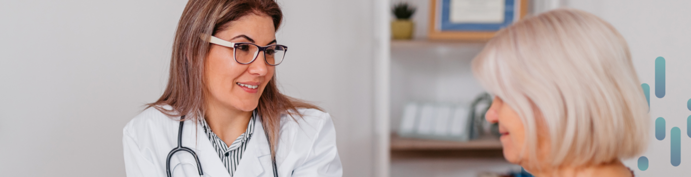 A doctor wearing a stethoscope and white coat consults with a patient