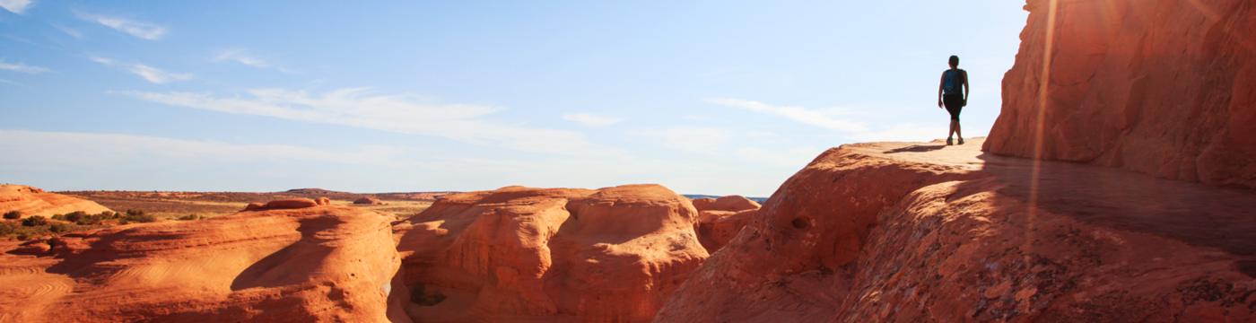 Distant view of a woman walking along a canyon 